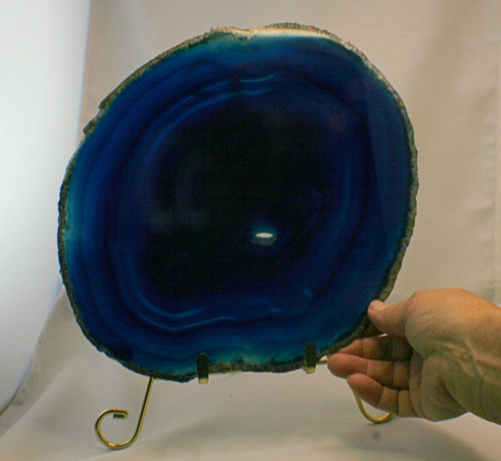 Solid blue agate slab with hand holding it for scale