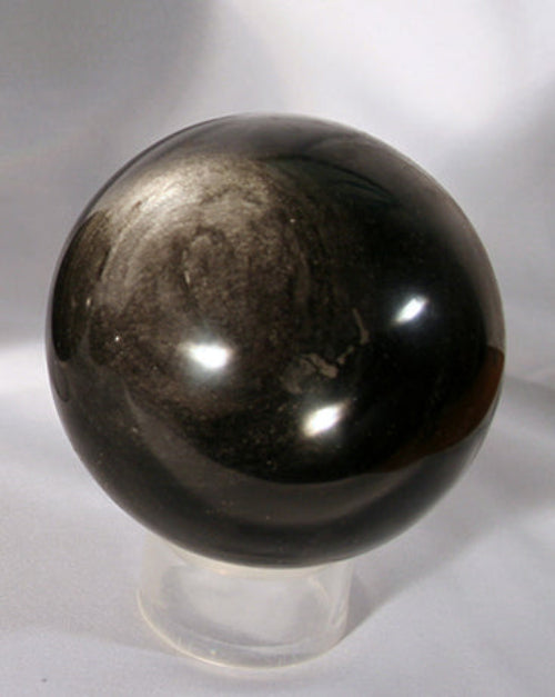 black sphere with gold sheen on stand